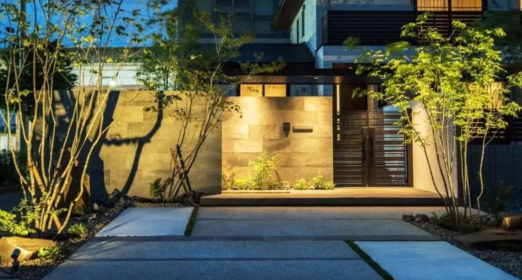 Stone-clad building entrance with professional landscape design